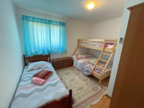 Cette petite chambre comprend 2 lits superposés et une fenêtre. dans l'établissement Villa Rosa Apartman, à Loborika