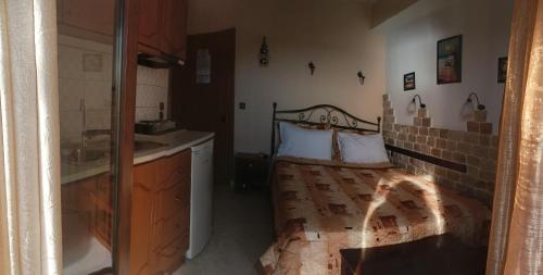 a bathroom with a bed and a sink in a room at ΠΑΝΣΙΟΝ ΑΓΓΕΛΟΣ ΜΑΝΑΡΗ in Ouranoupoli