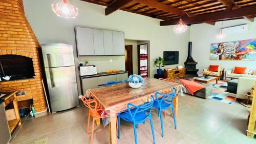 a kitchen and living room with a table and chairs at Recanto Jade in Taubaté