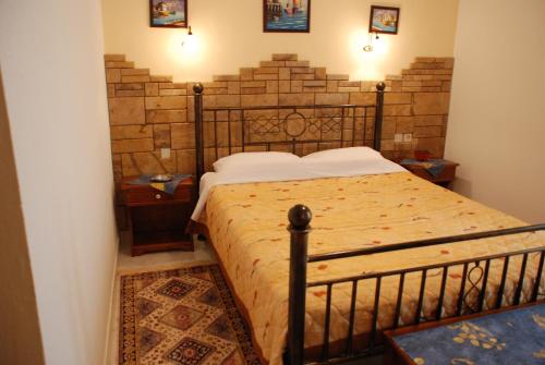 a bedroom with a bed with a brick wall at ΠΑΝΣΙΟΝ ΑΓΓΕΛΟΣ ΜΑΝΑΡΗ in Ouranoupoli