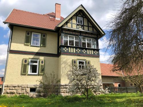 duży dom z czerwonym dachem i zielonymi okiennicami w obiekcie Ferienwohnung Landlust 