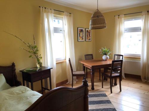 a dining room with a table and chairs and windows at Ferienwohnung Landlust 
