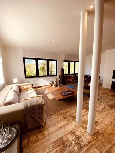 ein Wohnzimmer mit einem Sofa und einem Tisch in der Unterkunft Appartement 1 chambre - LAKE SIDE HOUSE in Rixensart