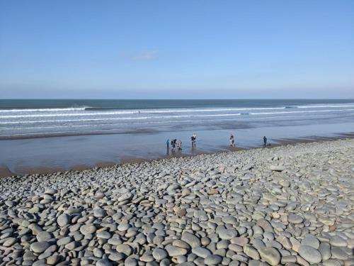 a group of people walking on a rocky beach at Home close to SW Coastal path in Hartland