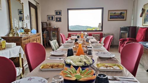 a long table in a room with pink chairs at Ca' Pietra di Nonno Pietro in Gavardo