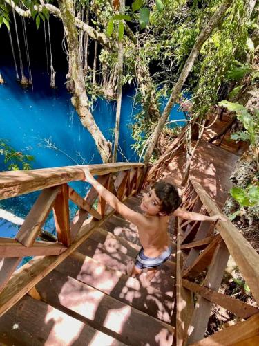 a young boy standing on a bridge over a river at Hotel Posada San Juan in Valladolid