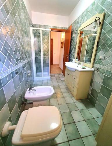 a bathroom with a toilet and a sink and a mirror at Mikey Appartamento con Terrazza in La Maddalena