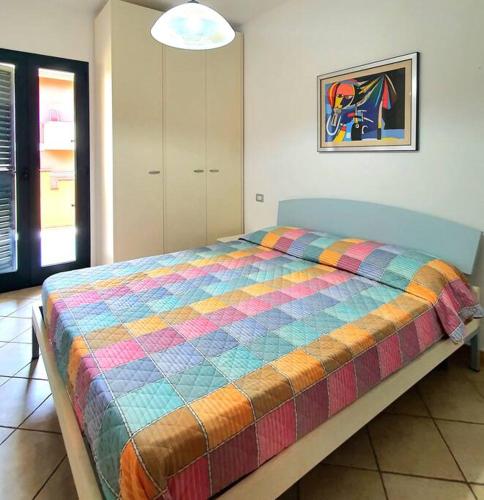 a bedroom with a bed with a colorful blanket at Mikey Appartamento con Terrazza in La Maddalena