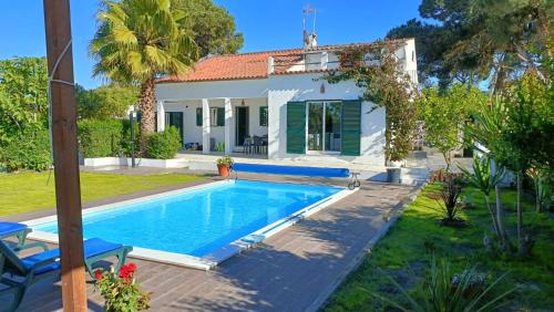 a villa with a swimming pool in front of a house at A Casa da Lagoa de Albufeira in Sesimbra