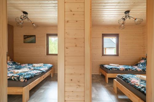 2 letti in una camera con pareti in legno di Wielewska Ostoja a Wiele
