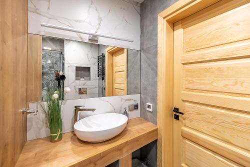 a bathroom with a white sink on a wooden counter at Wielewska Ostoja in Wiele