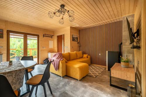 a living room with a yellow couch and a table at Wielewska Ostoja in Wiele