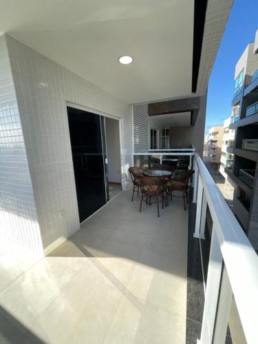 a balcony with a table and chairs on a building at Temporada Cabo Frio - Braga in Cabo Frio