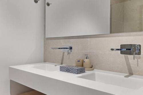een badkamerbar met 2 wastafels en een spiegel bij Luxury Apartment next to Golf Course in Marbella in Marbella