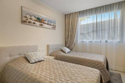 een hotelkamer met 2 bedden en een raam bij Luxury Apartment next to Golf Course in Marbella in Marbella