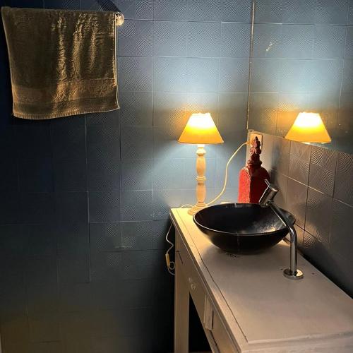 a bathroom with a sink and a lamp on a counter at Espaço Azul in Curitiba