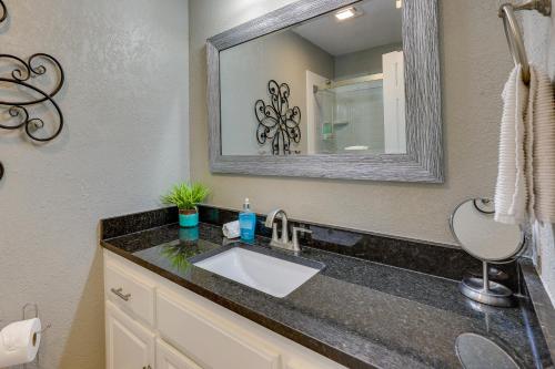 a bathroom with a sink and a mirror at Bella Vista Townhome with Deck Near Back 40 Trails! in Bella Vista