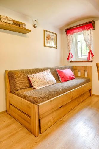 a wooden couch in a room with a window at Exkluzivní chalupa Podještědka s grilem a saunou in Světlá pod Ještědem