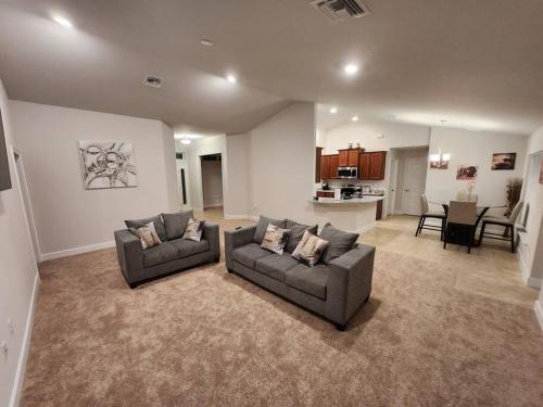 a living room with two couches and a kitchen at Home away from home in Port Charlotte
