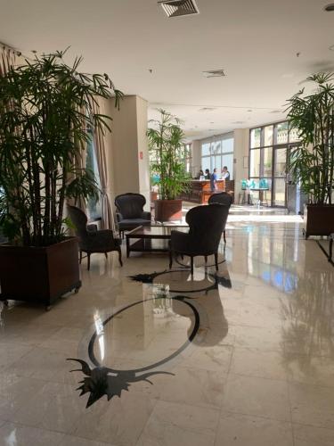 a lobby with chairs and a table and plants at EXECUTIVE SUITE 106a VILA OLIMPIA in Sao Paulo