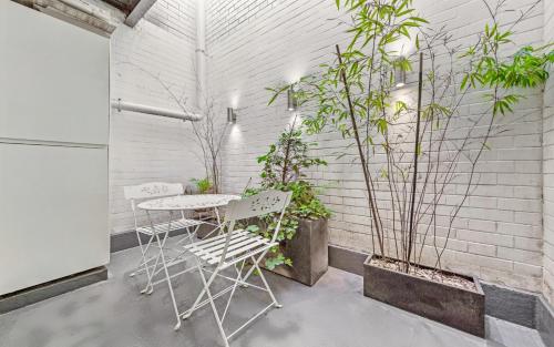 a patio with a table and chairs and plants at GARDEN Flat in Posh MEWS in London