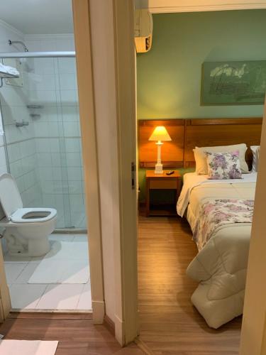 a bedroom with a bed and a bathroom with a toilet at EXECUTIVE SUITE 106a VILA OLIMPIA in Sao Paulo