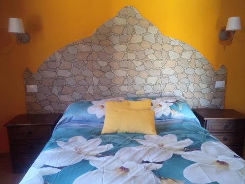 a bed with a large headboard with flowers on it at Casona Eladio in San José de Caideros