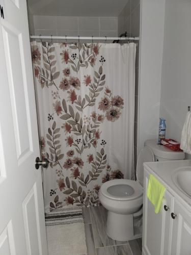 uma casa de banho com uma cortina de chuveiro com flores em Cozy Peaceful B&B em Rosedale