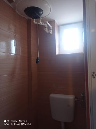 a bathroom with a toilet and a window and a light at Garsoniera confort I in Tulcea
