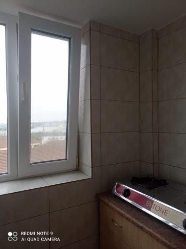 a bathroom with a window and a counter with a stove at Garsoniera confort I in Tulcea