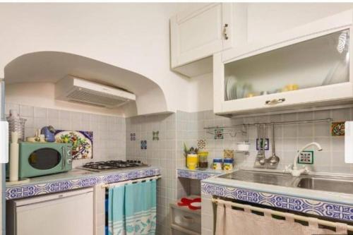 una cucina con lavandino e forno a microonde di Casa Centro storico Gallipoli a Gallipoli