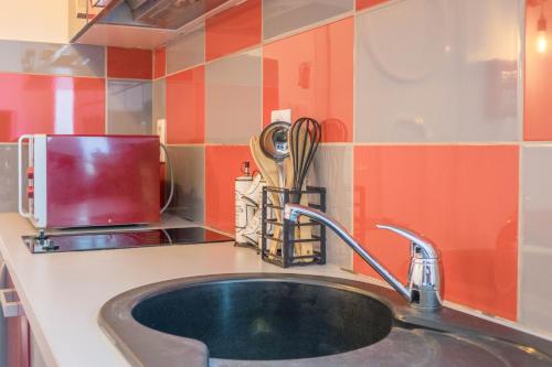 um balcão de cozinha com um lavatório e um micro-ondas em Studio Le Ligérien em Saint-Denis-de lʼHôtel