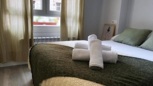 een slaapkamer met een bed met handdoeken erop bij La casita de Maria in Getxo