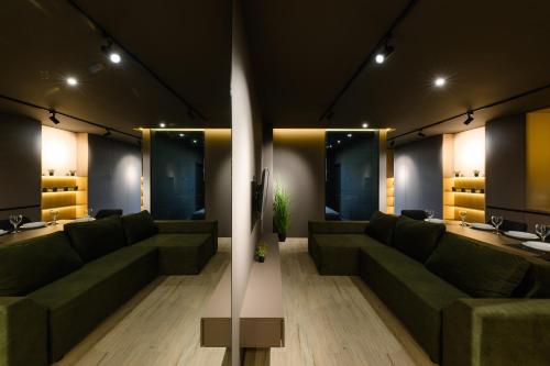 a living room with green couches and a table at Luxury Apartments-Belochka in Uzhhorod