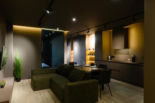 a living room with a green couch and a table at Luxury Apartments-Belochka in Uzhhorod