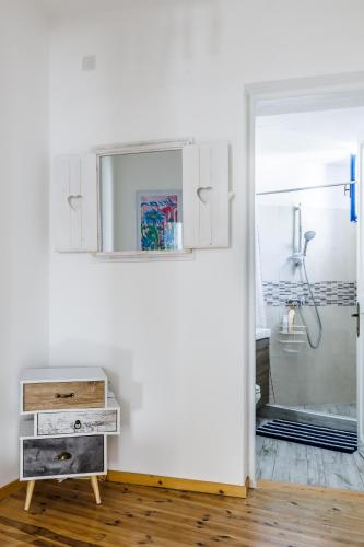 a bathroom with a shower and a dresser and a mirror at Chiarina's Spiti - Stylish & Peaceful in Old Town in Skopelos Town