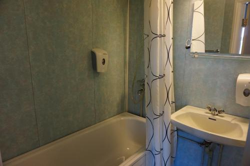 bagno con lavandino, vasca e lavandino di Verdde Hotel Lakselv a Lakselv