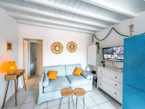 a living room with a blue couch and a tv at Cosy Home at Kalafatis beach - Cielo Homes in Kalafatis