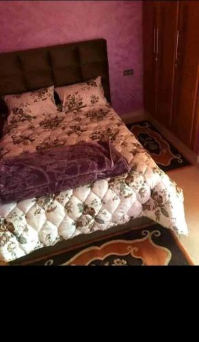 a bed in a bedroom with a pink wall at Shams doha in Beni Mellal