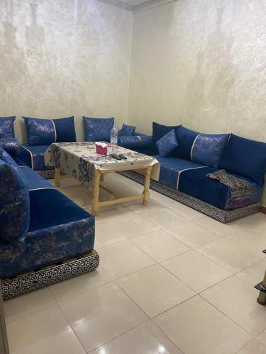 a living room with a blue couch and a table at Shams doha in Beni Mellal