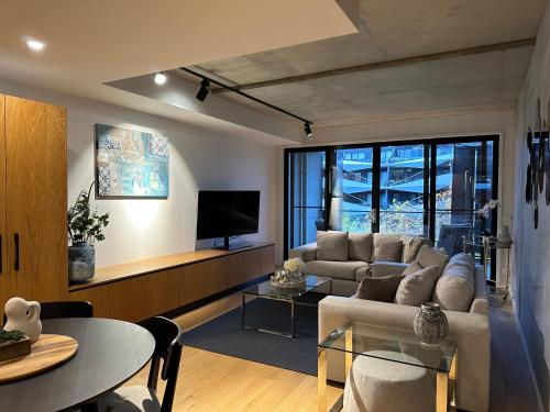 a living room with a couch and a tv at Palko - Luxury In the City in Canberra