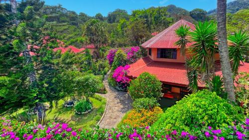 een huis met een rood dak en wat bloemen bij Boquete Garden Inn in Boquete