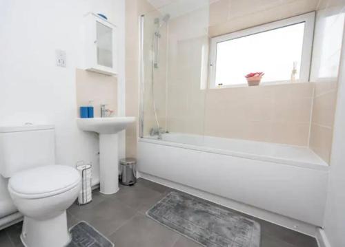 a bathroom with a toilet and a sink and a window at 1 Bedroom flat in Peterborough City centre in Peterborough