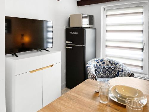 a kitchen with a table and a refrigerator at Tiny House Schwienhuck in Holtgast