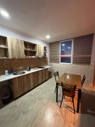 a kitchen with a table and chairs and a sink at Amazing Magnolia in Batumi