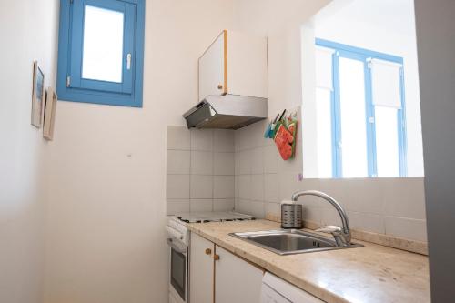 a small kitchen with a sink and a window at Casa Azzurra sul mare e centralissima in San Vito lo Capo