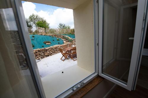 a window with a view of a swimming pool at Le clos des voisins in Verneuil