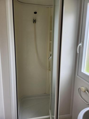 a shower with a glass door in a bathroom at A casinha do João in Alcobaça