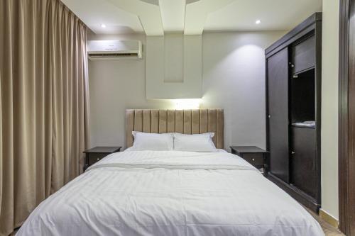 ein Schlafzimmer mit einem großen Bett mit zwei Tischen in der Unterkunft سكاي قاردن sky garden in Riad