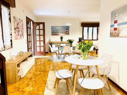 una sala da pranzo con tavoli e sedie bianchi di Villa Riviera by the Sea a Lignano Sabbiadoro